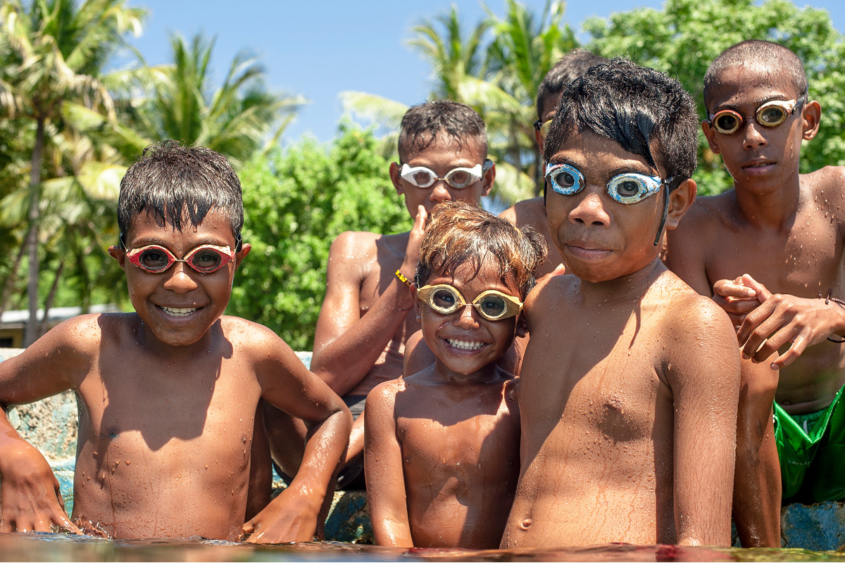 Kids with wooden handmade goggles in Pura island, Alor archipelago